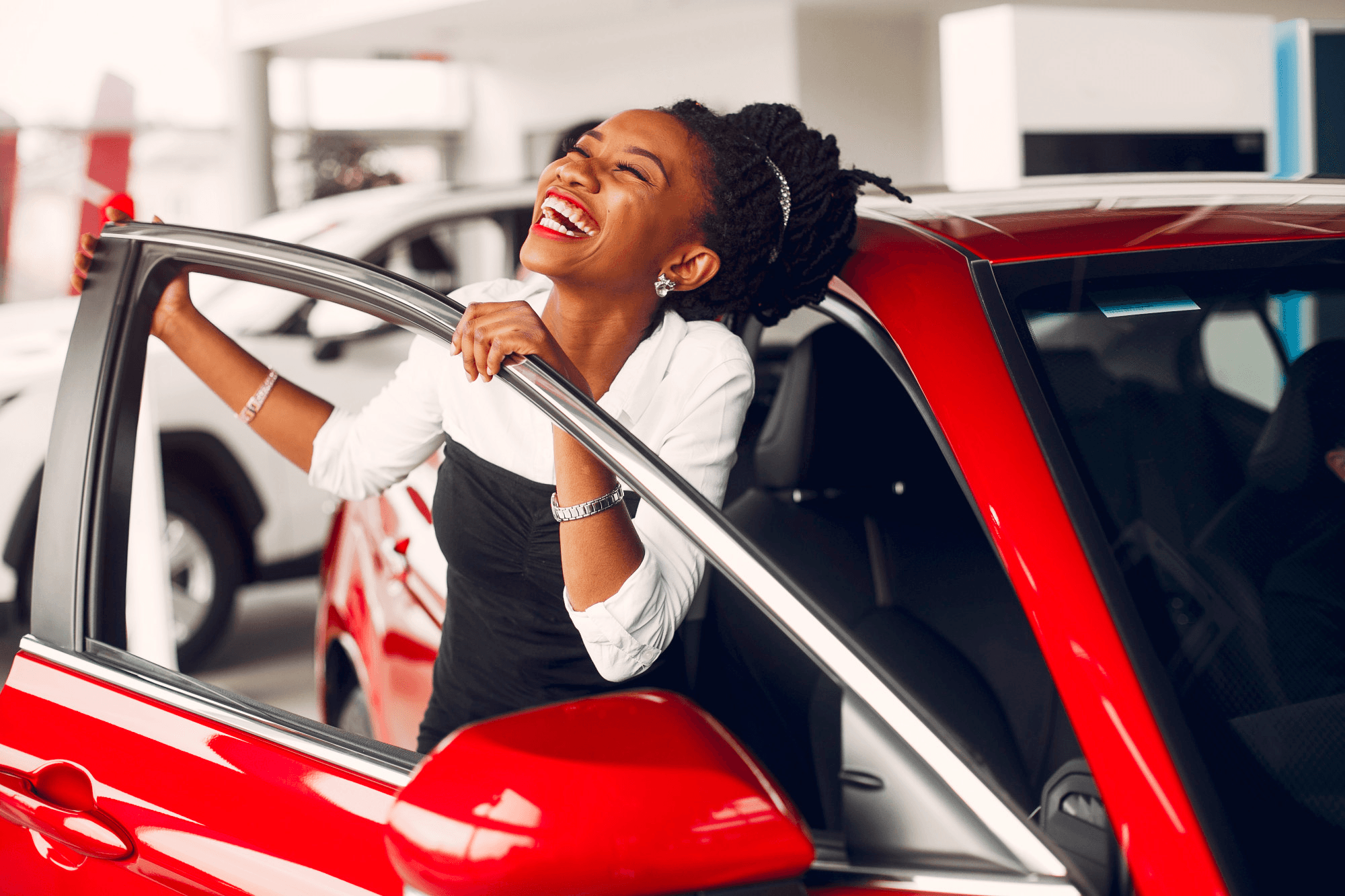 Faça a simulação do consórcio de carros Embracon e conquiste o seu próximo carro, sem entrada e sem juros Mulher rindo de felicidade saindo pela porta do seu carro vermelho 0km comprado com o consórcio Embracon