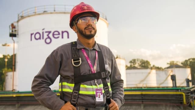 Funcionario em frente ao logo da raizen em um silo