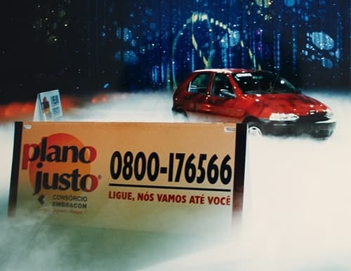 Placa do Plano Justo com veículo vermelho ao fundo